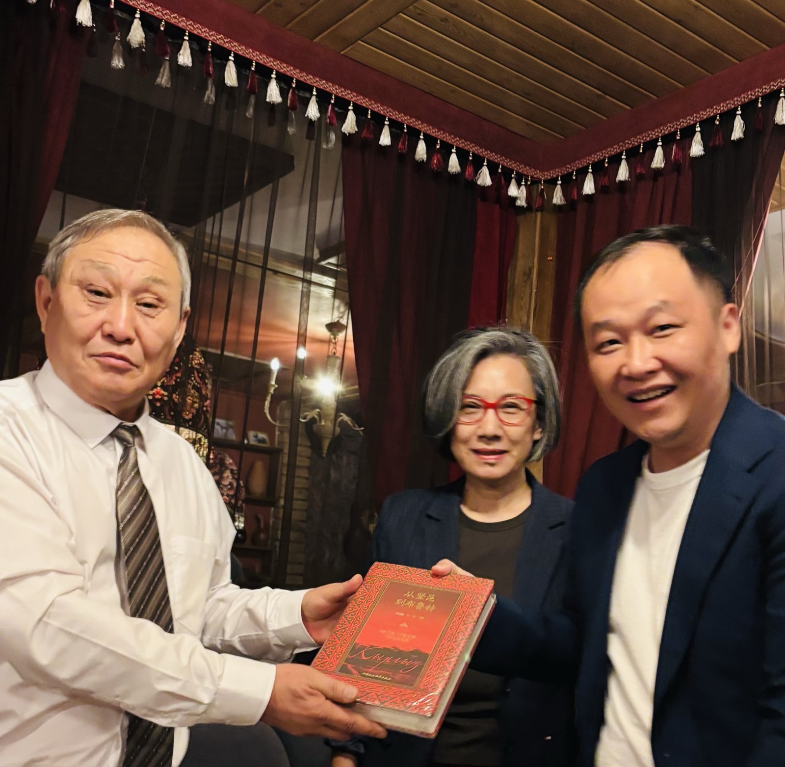 吉尔吉斯斯坦会晤期间，三位与会人员手持书籍合影
